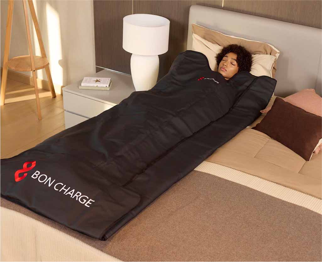 Woman Laying In Sauna Blanket On Bed